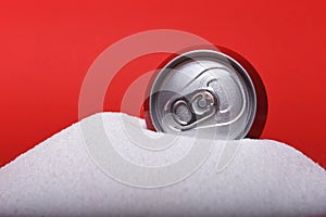 Cola refreshing drink can sitting in pure white sugar mountain