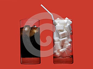 Cola refreshing drink and glass full of sugar cubes and straw representing massive calories content