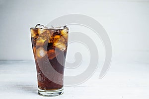 .Cola soda in a glass on a white table photo