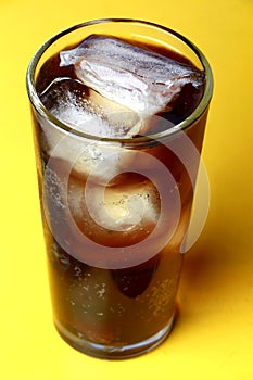 Cola soda poured in a glass with ice cubes