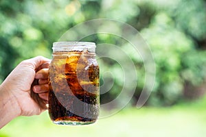 Cola cola sparkling water in a glass with ice