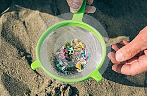 Colander with microplastics on the beach