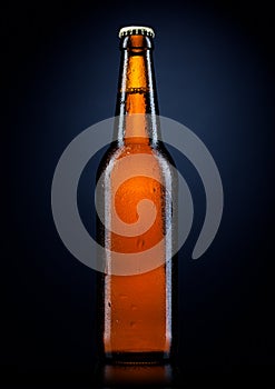 Cold beer bottle with drops, on black