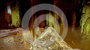 Cold beer bottles with ice cubes. Dolly shot