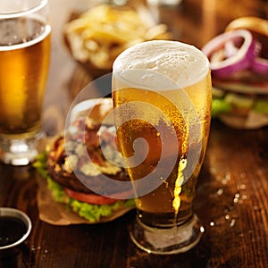 Cold beer with foamy head and burgers
