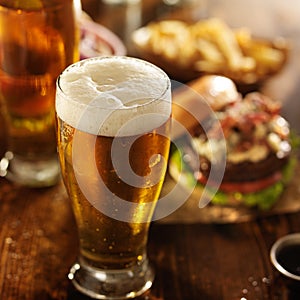 Cold beer with foamy head and burgers