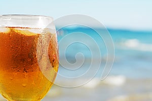 Cold beer in glass on beach, closeup. Space for text