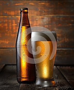 Cold beer in glass and bottle on a dark wooden background