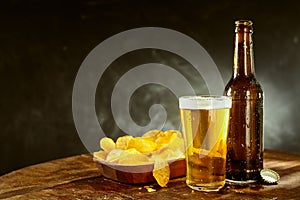 Cold beer and potato crisps on a bar counter