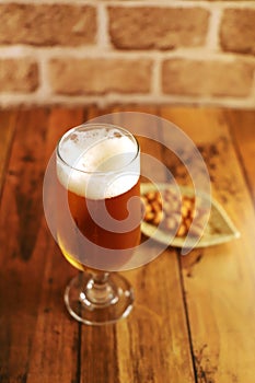 Cold beer poured into a glass and snack nuts