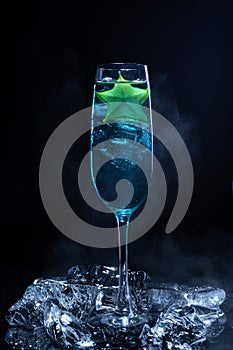 Cold blue cocktail with a star fruit garish