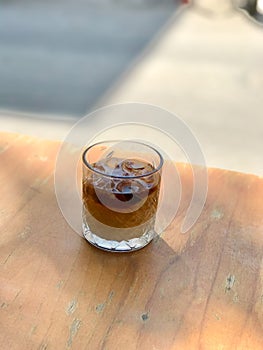 Cold Brew Coffee with Milk and Ice on Wooden Table at Street Cafe shop