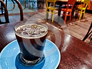 Cold brew iced fresh Americano coffee served in a glass on wooden table