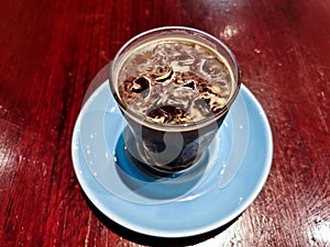 Cold brew iced fresh Americano coffee served in a glass on wooden table
