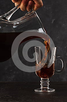Cold brewing coffs poured from carafe into a glass