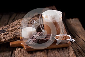 Cold Chocolate Milk drink and chocolate bar on wooden background