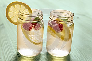 Cold citrus soda in glass jar on green table