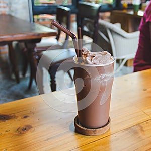 Cold cocoa in a glass on a wooden table