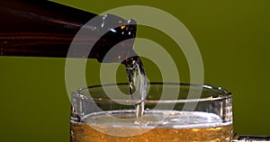Cold Craft light Beer in a glass with water drops. Pouring Beer. Pint of Beer. Bottle of beer into Glass. Adver