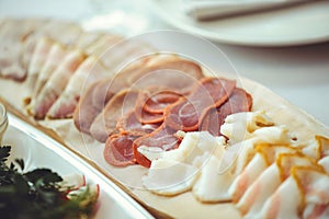 Cold cuts with ham, bacon, salami and bacon on a light background. Meat platter