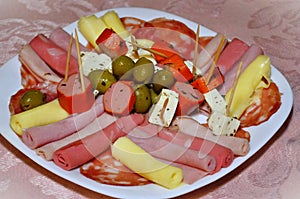 Cold cuts plate containing: cheese, sausage, ham, olives, salami and mortadella