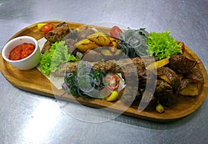 Cold cuts with potatoes on a wooden board