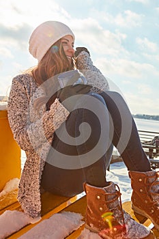 Cold days and warm thoughts. a beautiful woman enjoying a hot beverage while sitting outside in the snow.