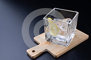 Cold drink in a glass on the kitchen table. Lemon and ice with water the best way to cool off on a summer day