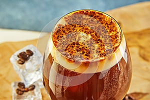 Cold drink or Nitro Coffee drink in a glass with bubble foam and ice, top view