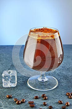 Cold drink or Nitro Coffee drink in a glass with foam, ice and coffee beans