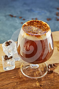 Cold drink or Nitro Coffee drink in a glass with foam, ice and coffee beans