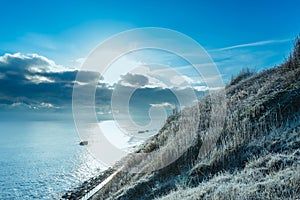 Cold, early morning view of a sloping cliff covered with frost.