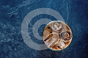 Cold espresso coffee on iced with milk. Iced coffee in tall glass on dark background ideal for cafe beverage menu.m Black backgrou