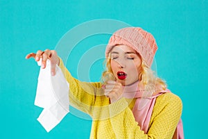 Cold and flu season- portrait of a woman in hat and scarf coughing