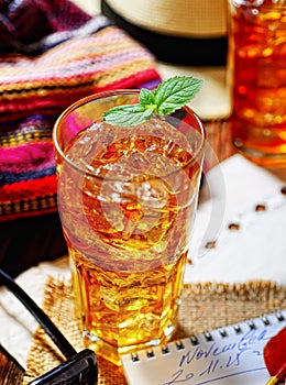 Cold fragrant tea in a glass on the original napkin, mint leaves