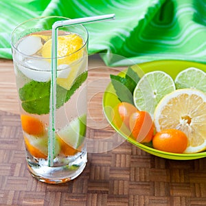 Cold fresh drink with lemon, lime, kumquat and mint.