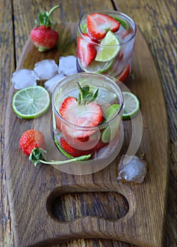 Cold fresh lemonade drink with strawberry and lime close up