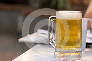 The cold glass beer with froth