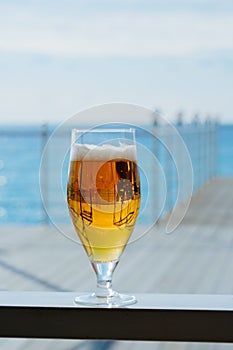 cold glass of beer on a sea restaurant terrace in a sunny day, blurred background selective focus