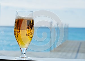 cold glass of beer on a sea restaurant terrace in a sunny day, copy space blurred background