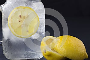 Cold glass of water with ice cubes and a slice of lemon.