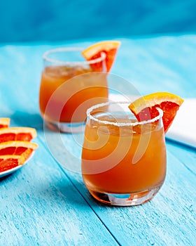 Cold Grapefrut Cocktail on a bright blue background