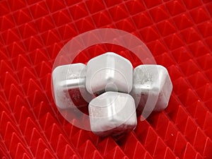 Cold ice cubes on red background