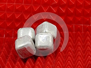 Cold ice cubes on red background