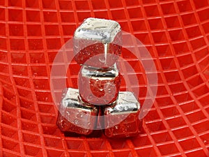 Cold ice cubes on red background