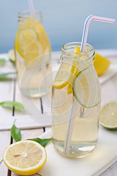 Cold lemon drink with slices of lime and lemon