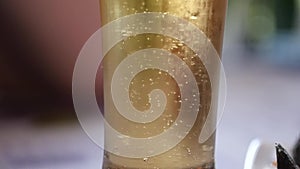 Cold light beer in a glass with water drops. Beer bubbles, slow motion