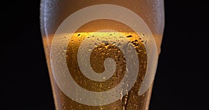 Cold Light Beer in a glass with water drops. Craft Beer close up.