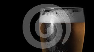 Cold Light Beer in glass with water drops ever matte black background, border design. Craft Beer close up. Copy space