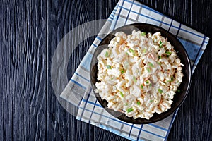 Cold macaroni salad in a black bowl